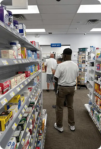 Shoppers browsing health product aisles at PharmaHealth Pharmacy